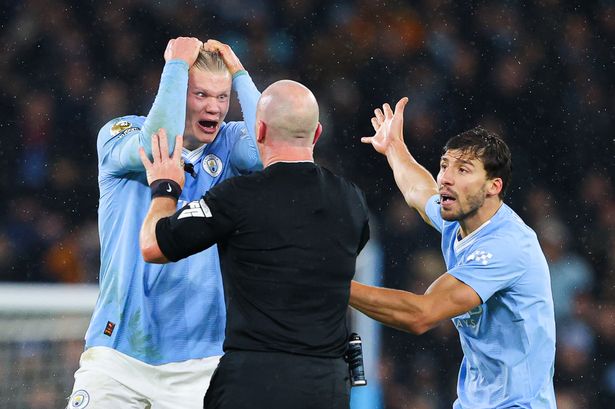 Referee Simon Hooper is surrounded by Erling Haaland, Mateo Kovačić and Rúben Dias of Manchester City after he stopped the game to award Manchester City a free kick and deny Jack Grealish (not pictured) the chance to play on and have a goal scoring chance during the Premier League match between Manchester City and Tottenham Hotspur at Etihad Stadium on December 03, 2023 in Manchester, England.